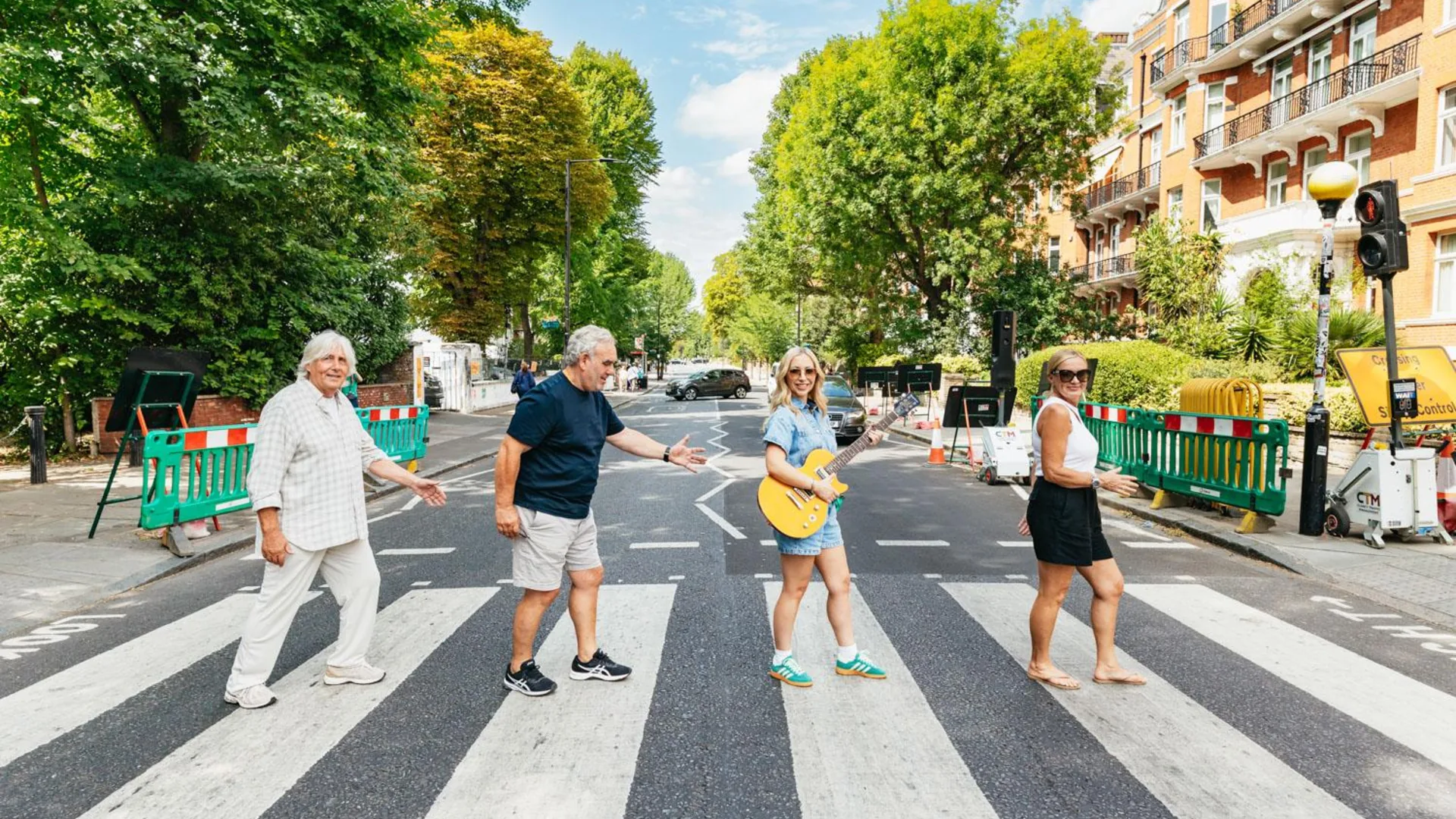 Guests walking over the Abbey Road zebra crossing, from the Rock N Roll Beatles cab tour listing
