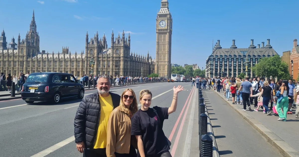 A London black cab on Westminster Bridge with Big Ben and the Houses of Parliament behind, guests from a private cab tour in front