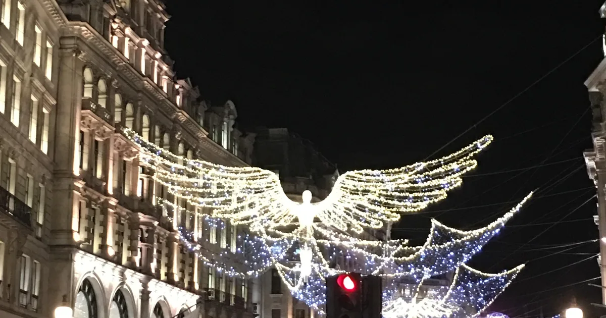 The Christmas angels lit up over Regent Street at night, seen on a black cab Christmas lights tour